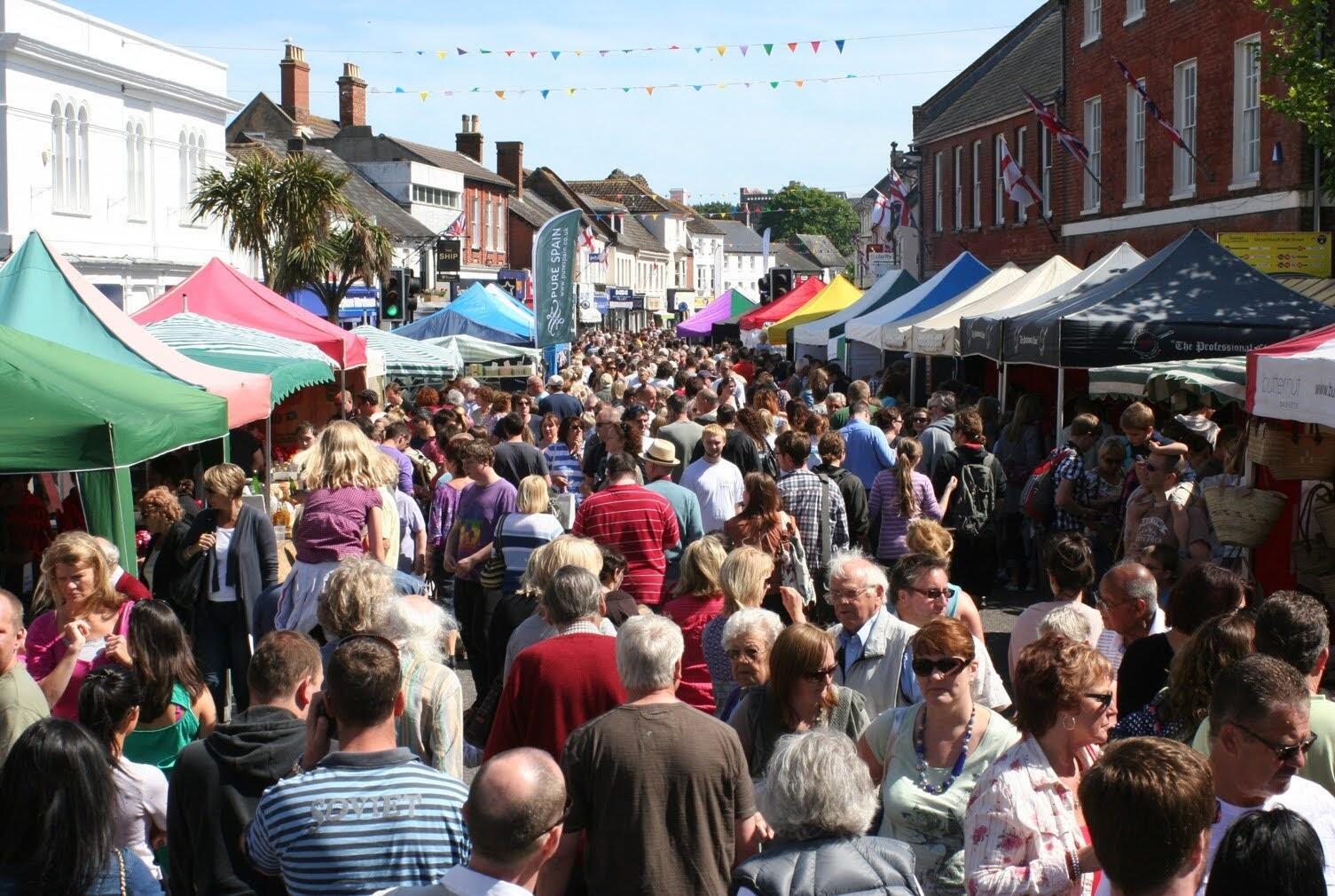 crowds of people at a street market in devizes wiltshire on a sunny day